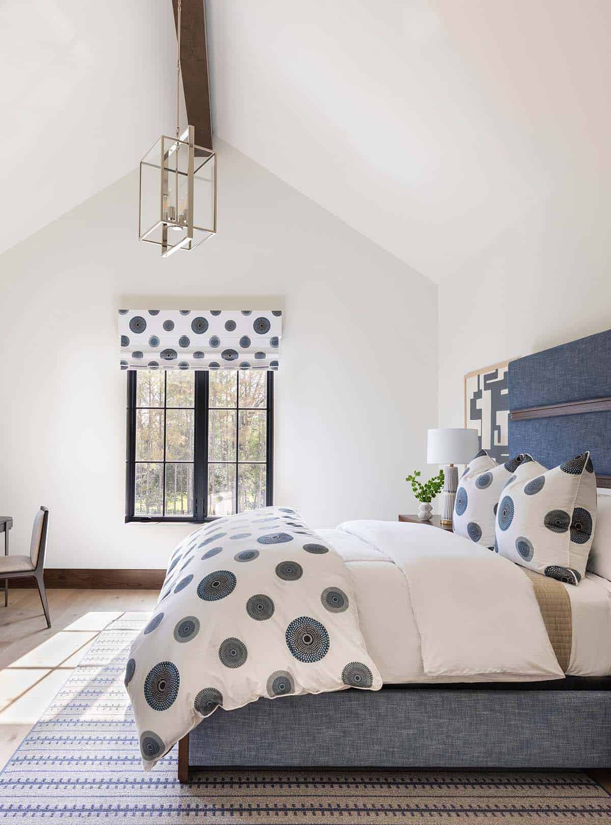 Bedroom with vaulted ceiling, lantern pendant, and blue dotted bedding