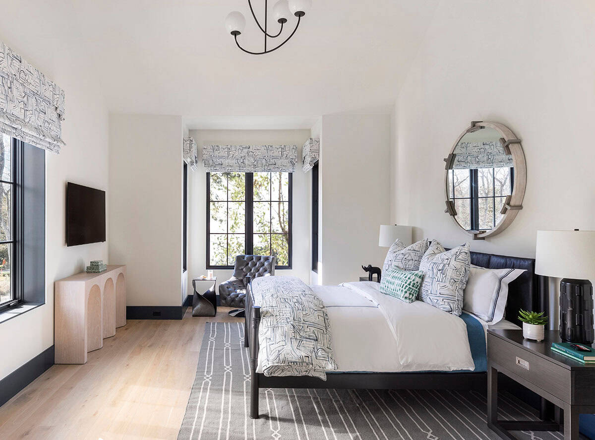 Bedroom with black leather headboard and round wood-framed mirror