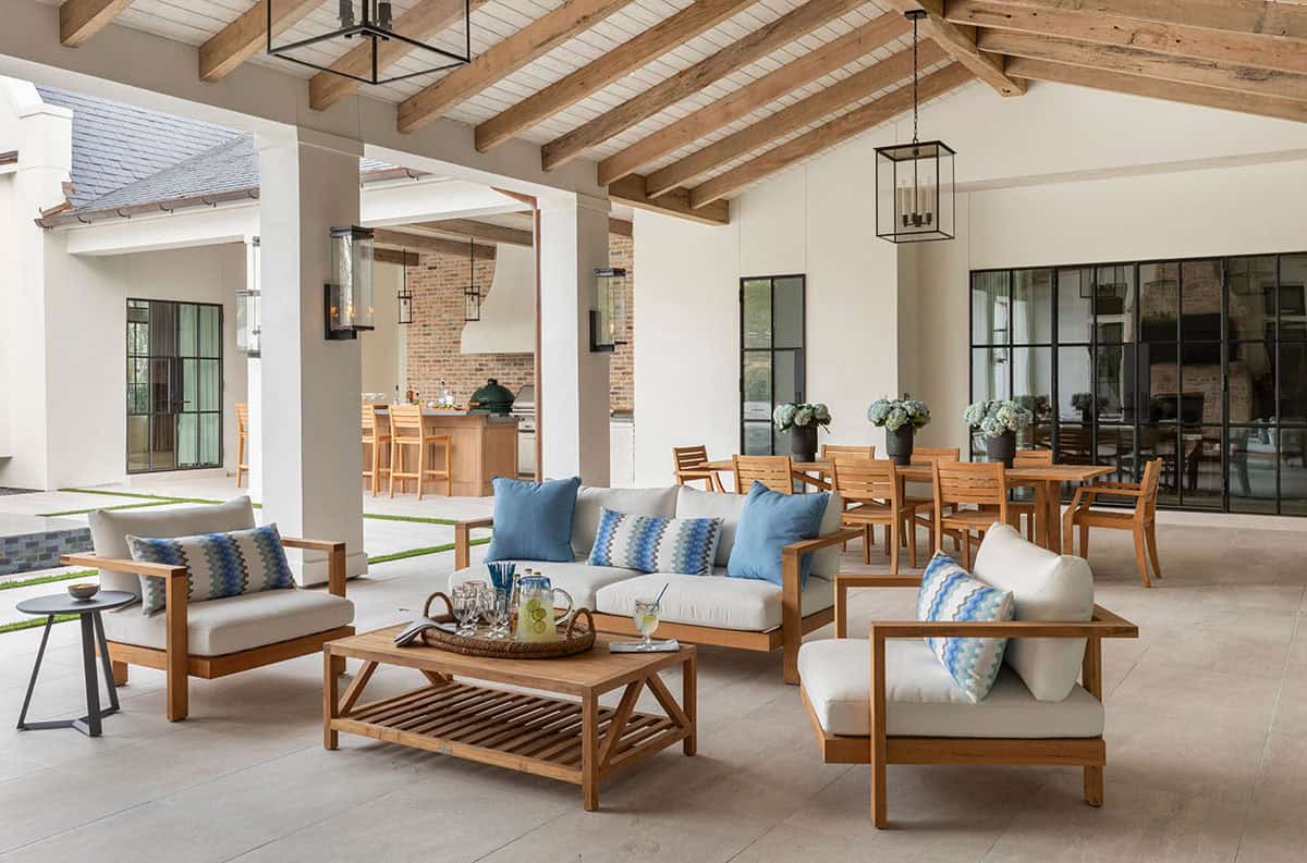 Outdoor living and dining area with teak furniture and brick kitchen