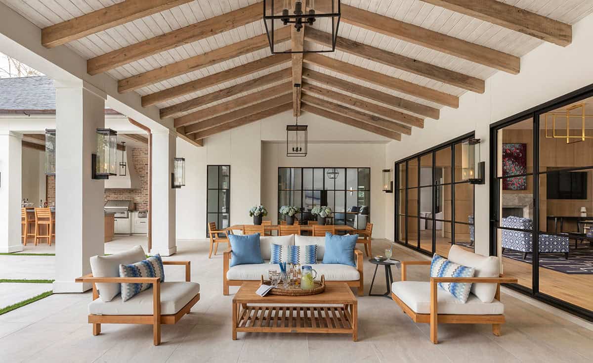 Covered patio lounge with teak furniture overlooking pool and interior