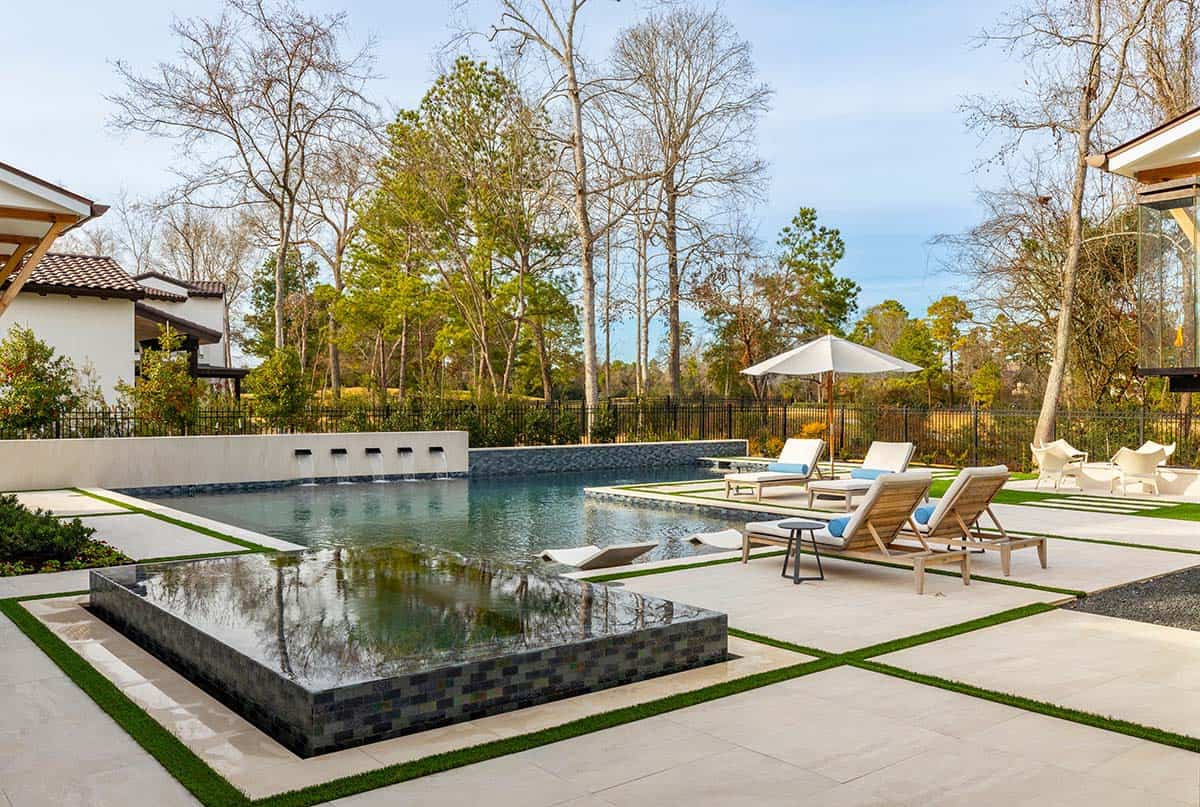 Backyard pool with raised spa, water feature, and lounge chairs