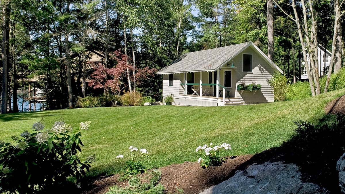 Small guest cottage tucked among trees on the lawn