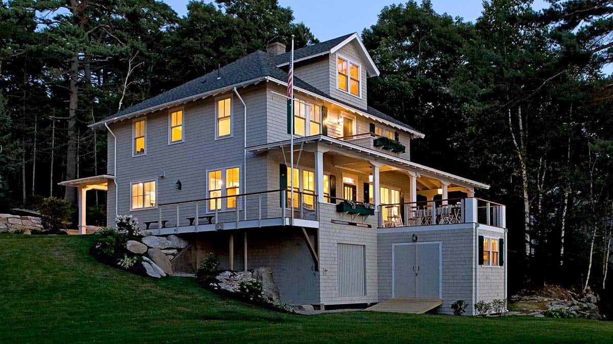Cedar shingle cottage exterior lit up at dusk