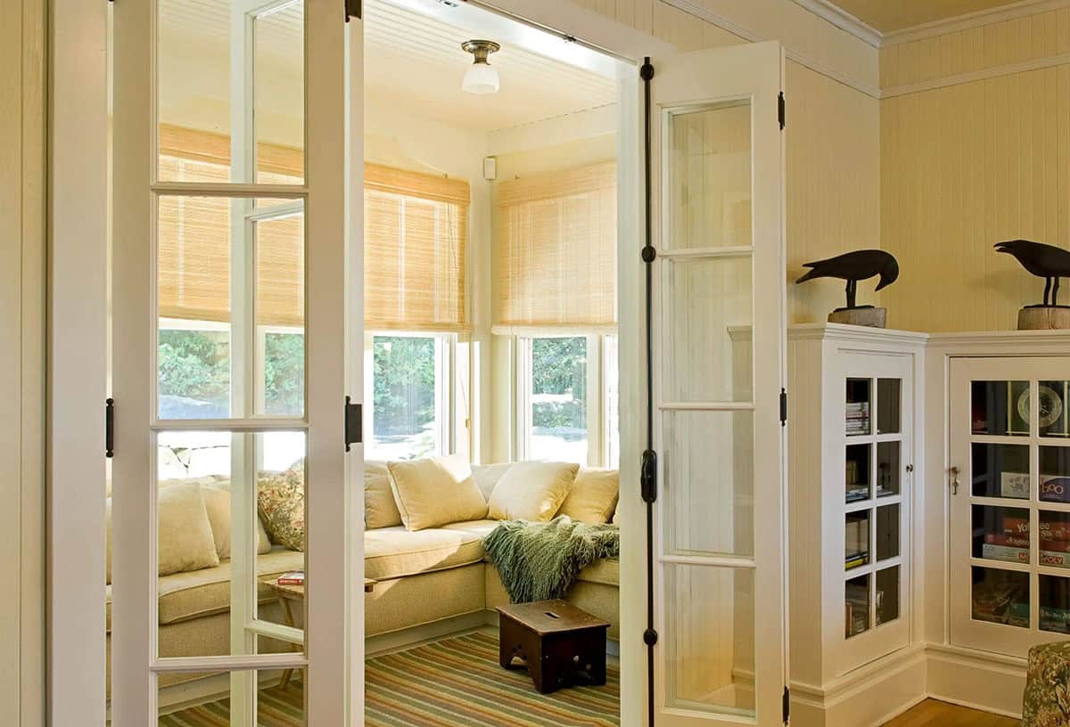 Cozy sunroom with beige sectional seen through glass doors