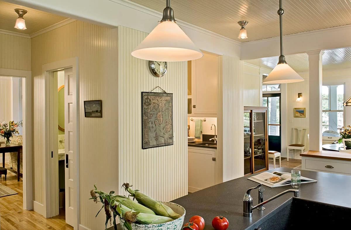 Hallway view into cottage kitchen with nautical map decor