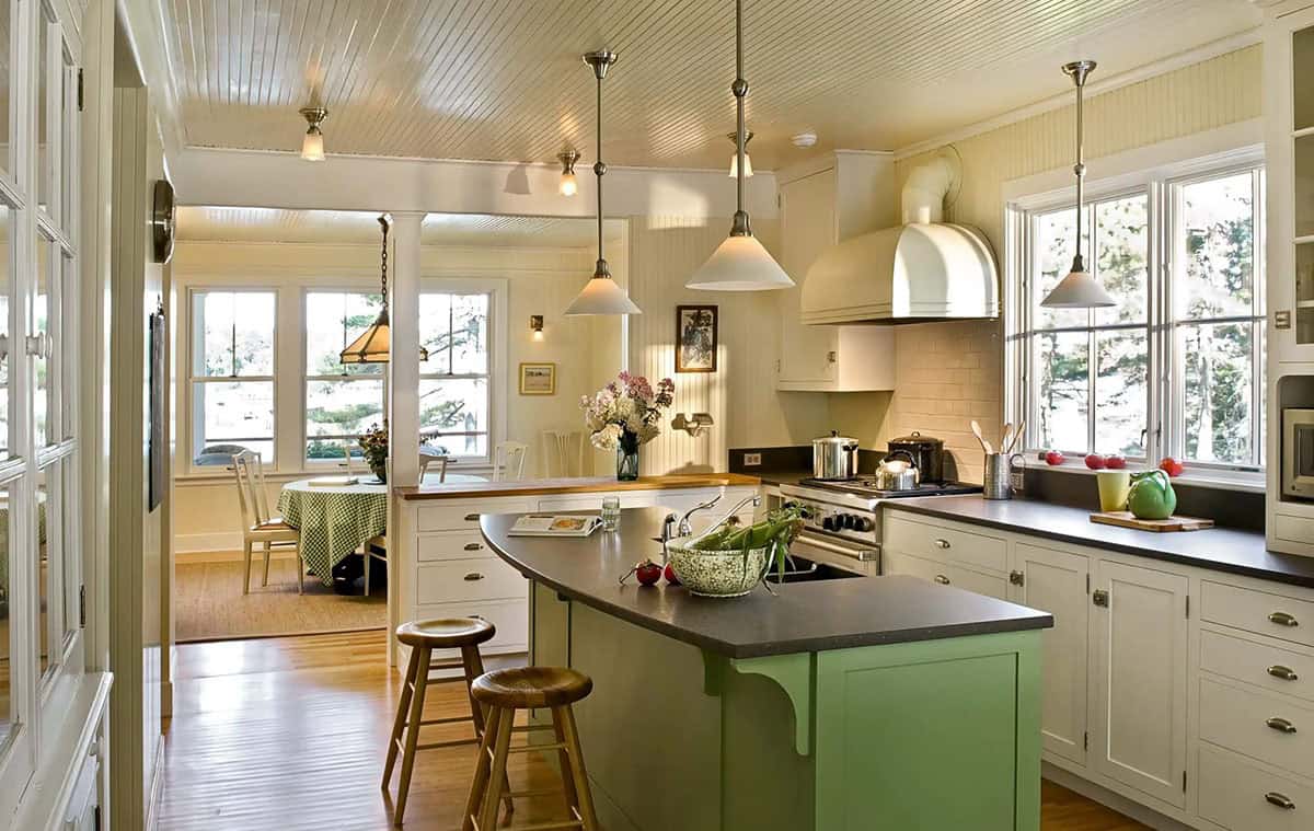 Kitchen with green island opening into dining and porch area