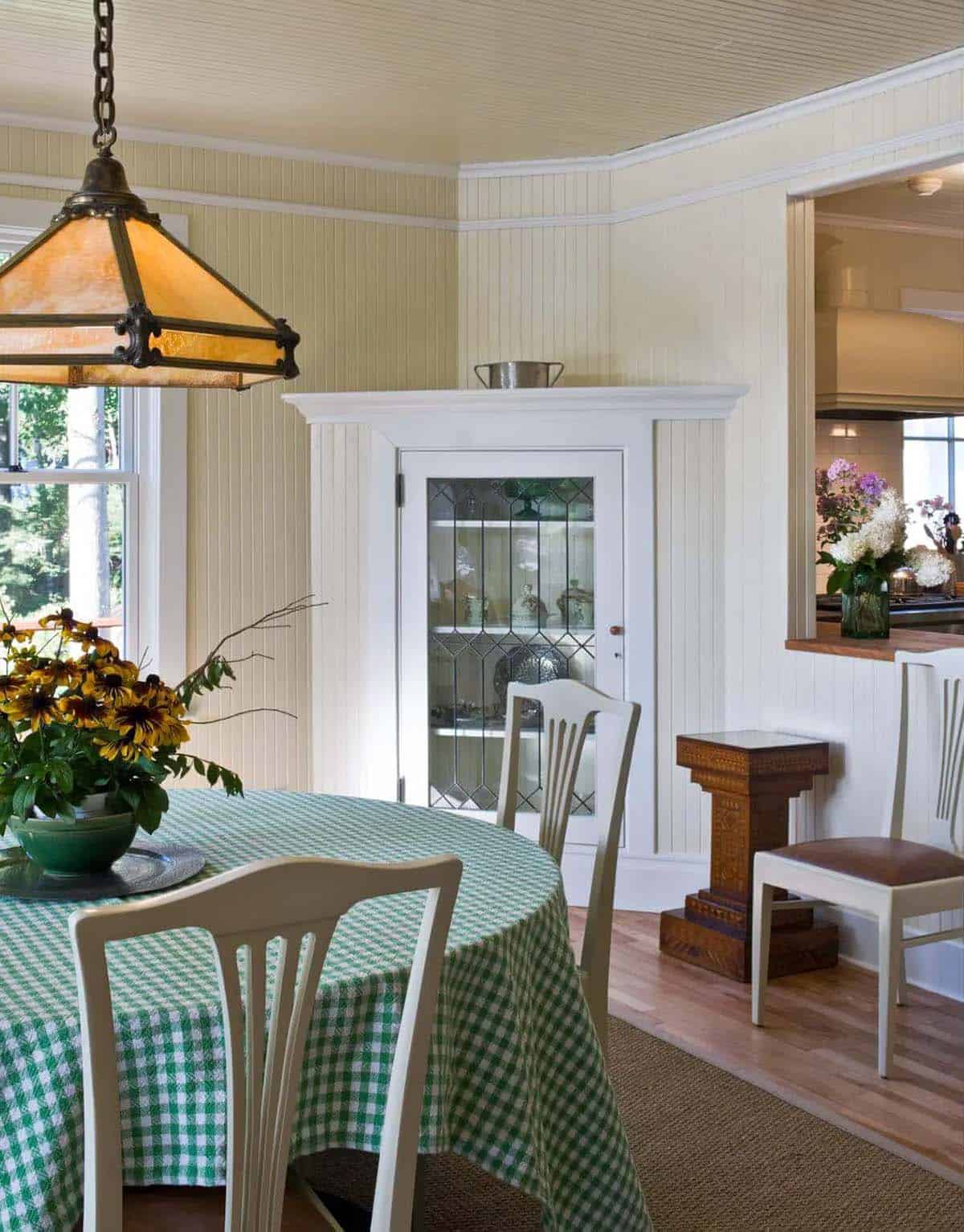 Dining nook with checkered tablecloth and antique corner cabinet