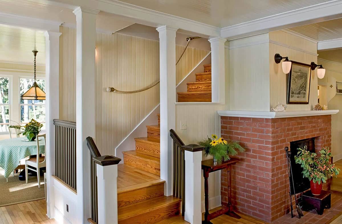 Entry hall with brick fireplace and wooden staircase