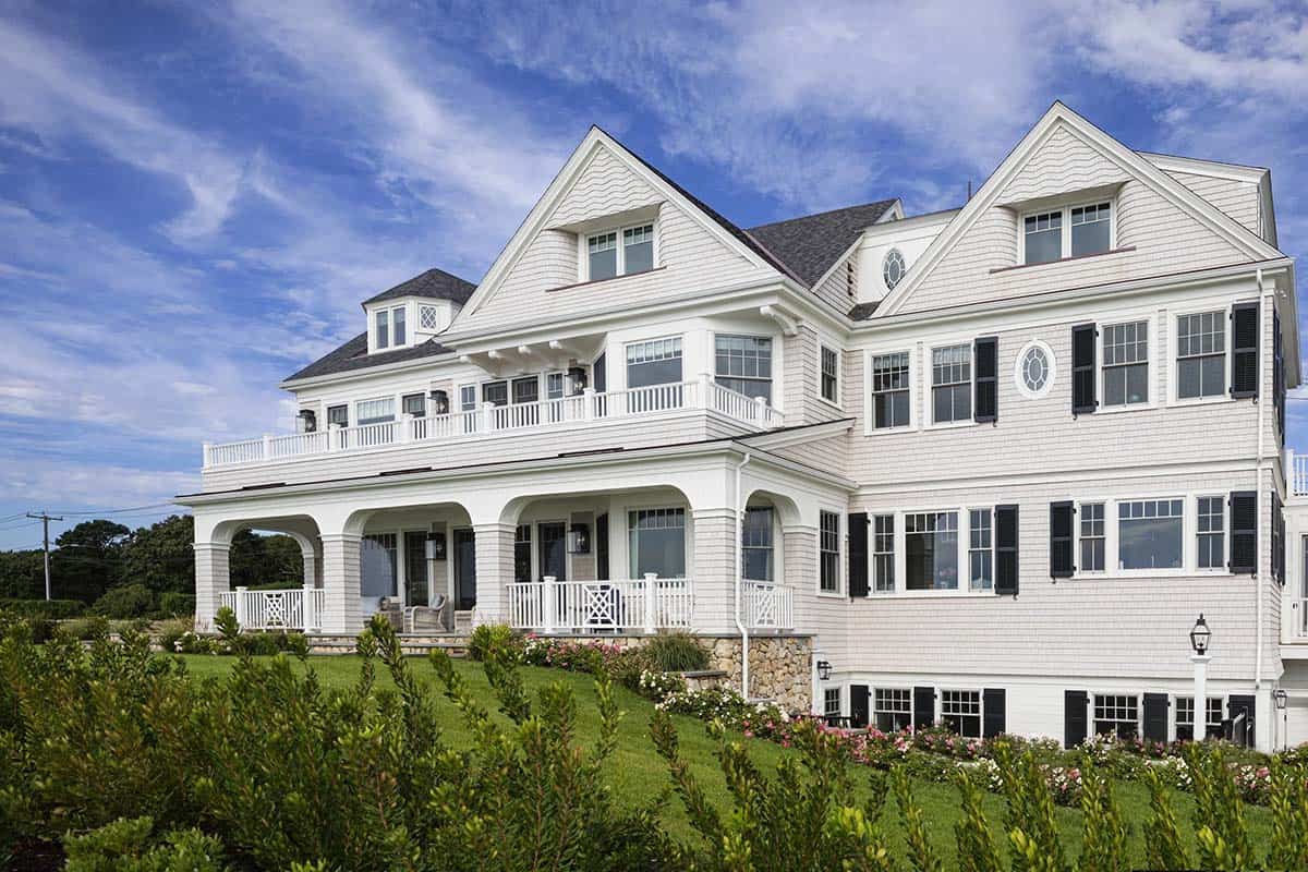 Shingle-style coastal home exterior with wraparound porch