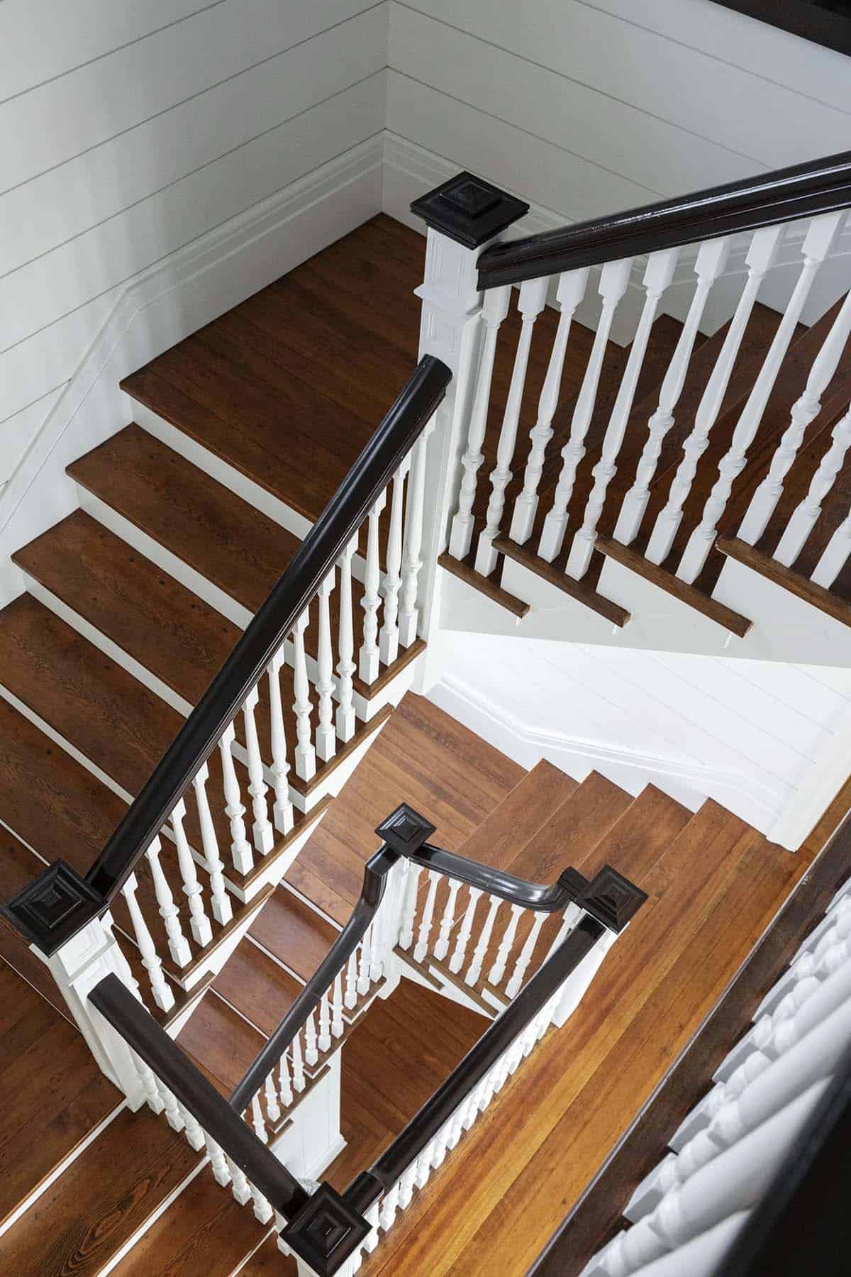 Bird's-eye view of dark wood staircase railings and oak treads