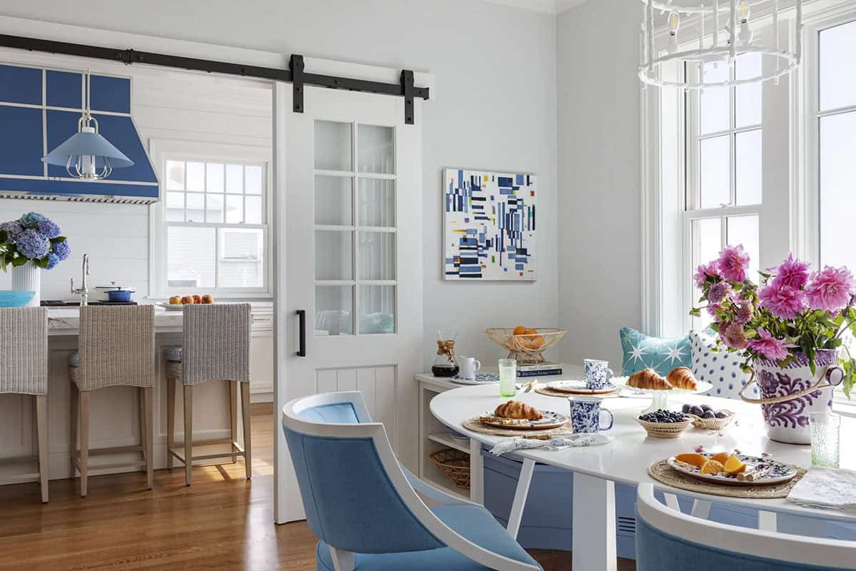 Kitchen and dining area connected by glass-paned barn doors