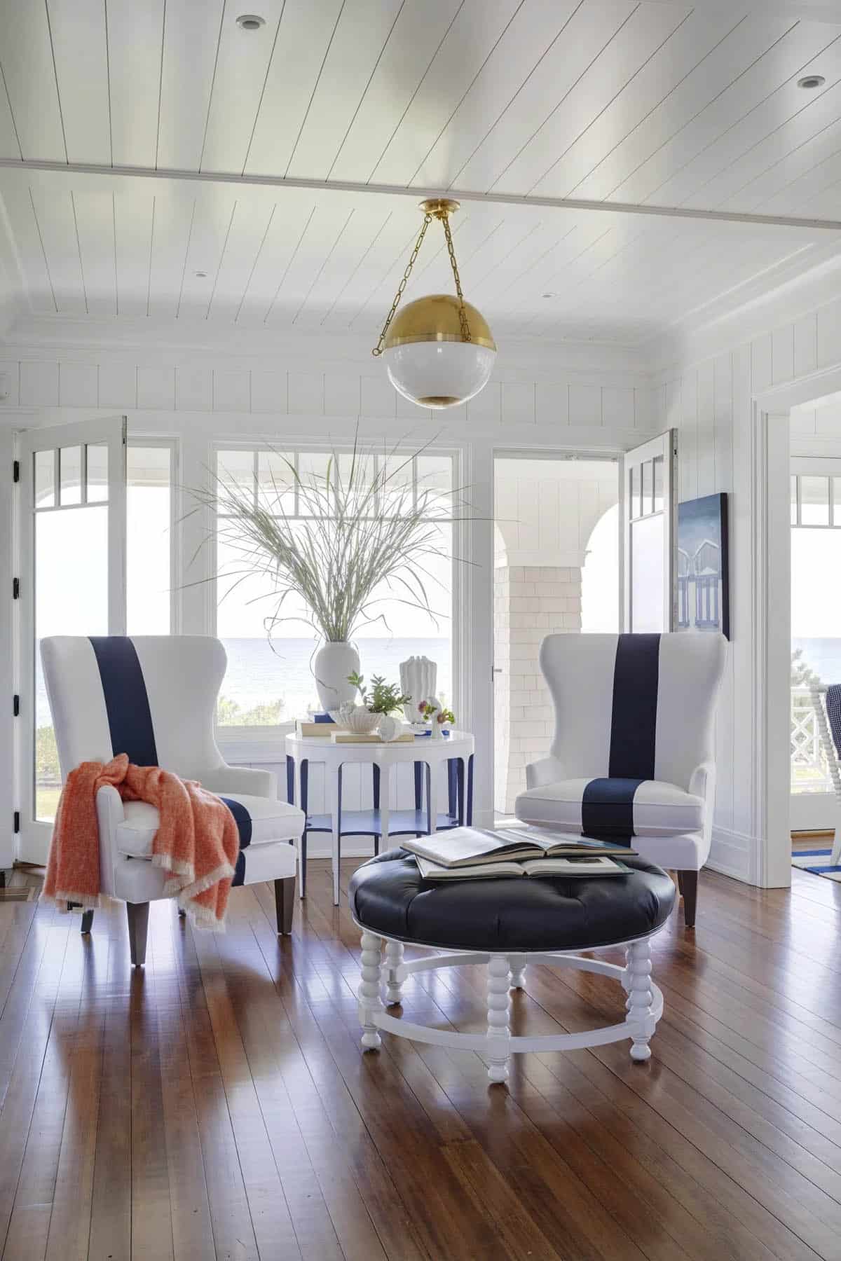 Sunroom with navy striped chairs and ocean-facing French doors