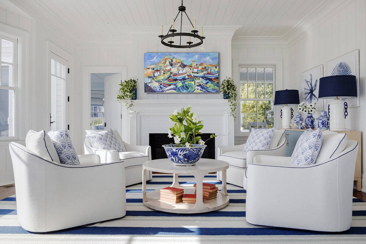 White swivel chairs around coffee table with coastal art above