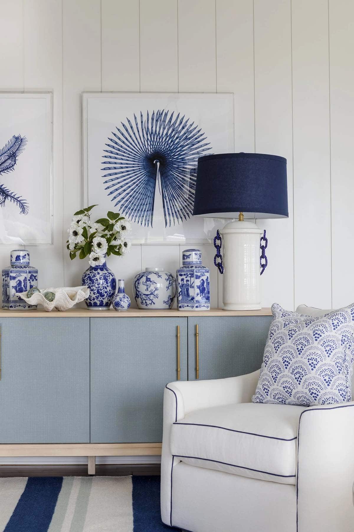 Blue and white credenza styled with ginger jars and coral lamp