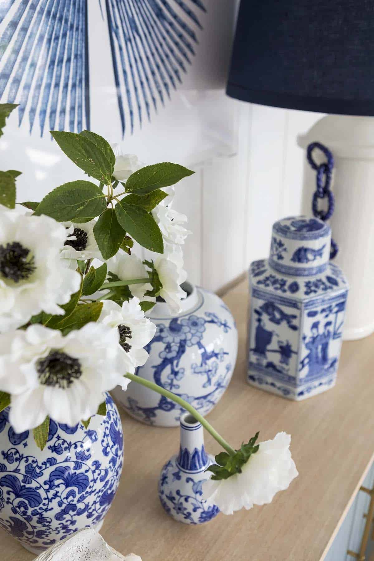 Close-up of blue and white ginger jars with white anemones