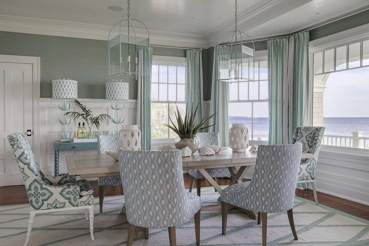 Green and white dining room with striped curtains and ocean view