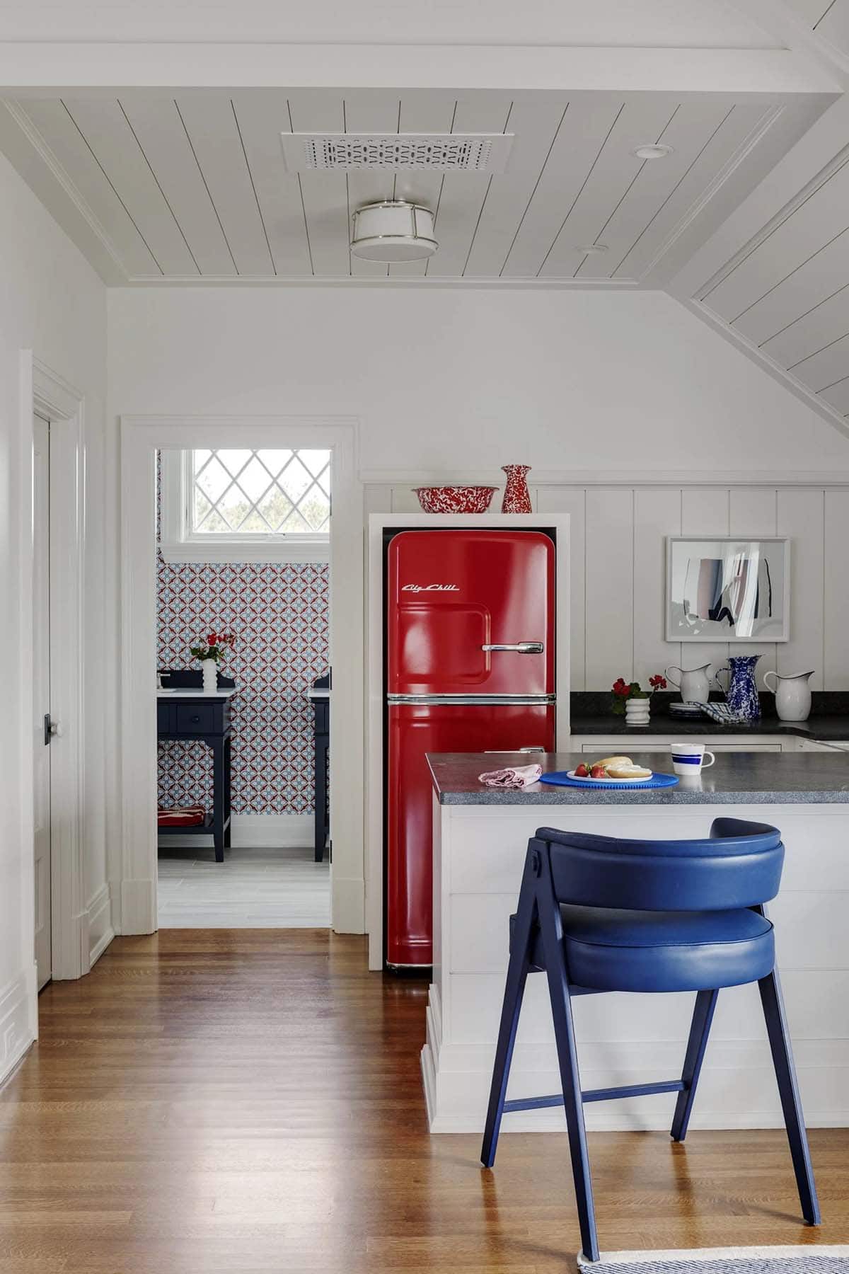 Kitchenette with red Big Chill fridge beside navy bar stool