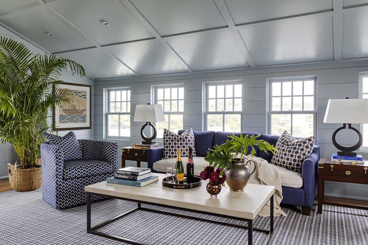 Blue paneled sitting room with striped rug and navy sofa