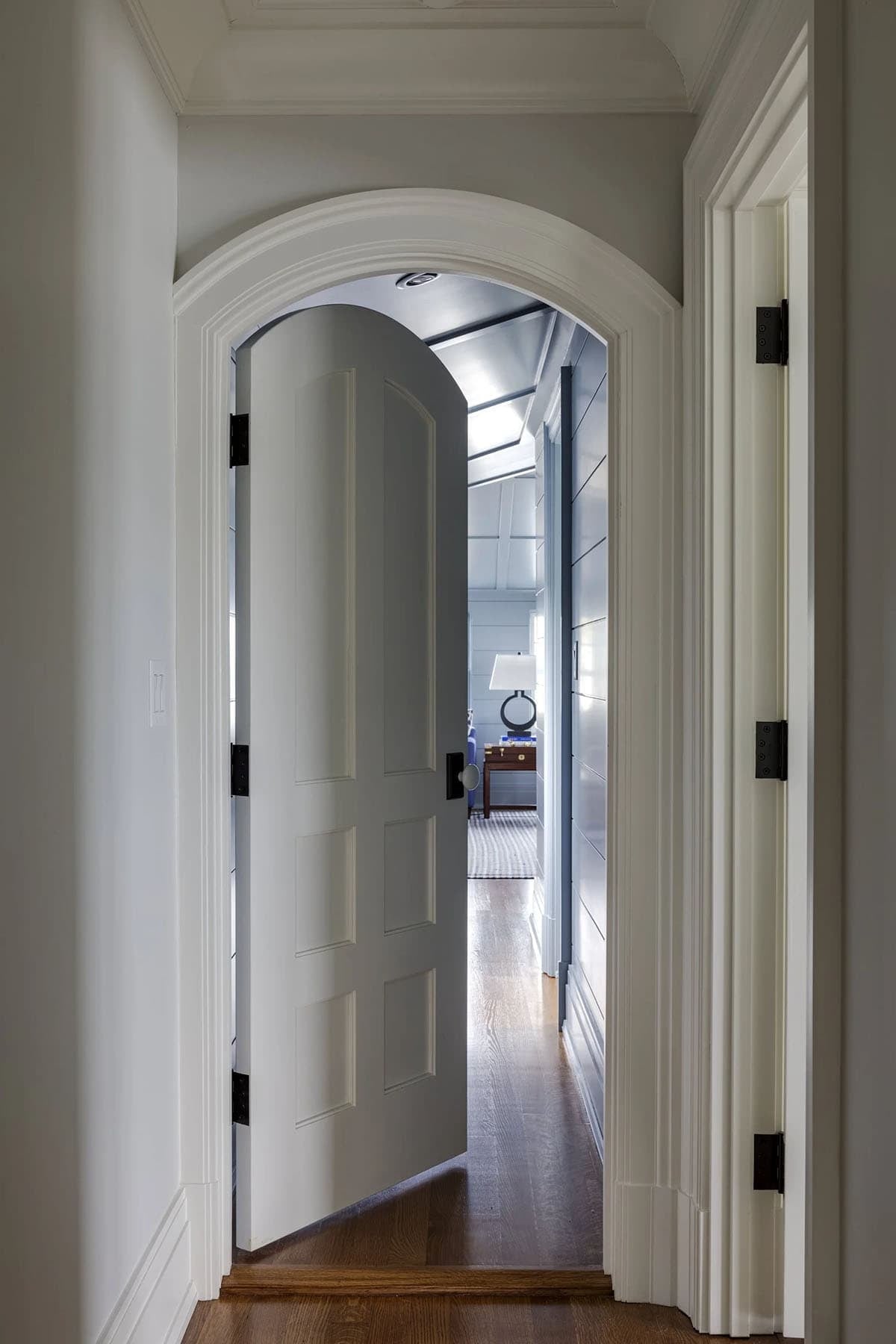 Arched doorway framing a glimpse of a blue paneled room
