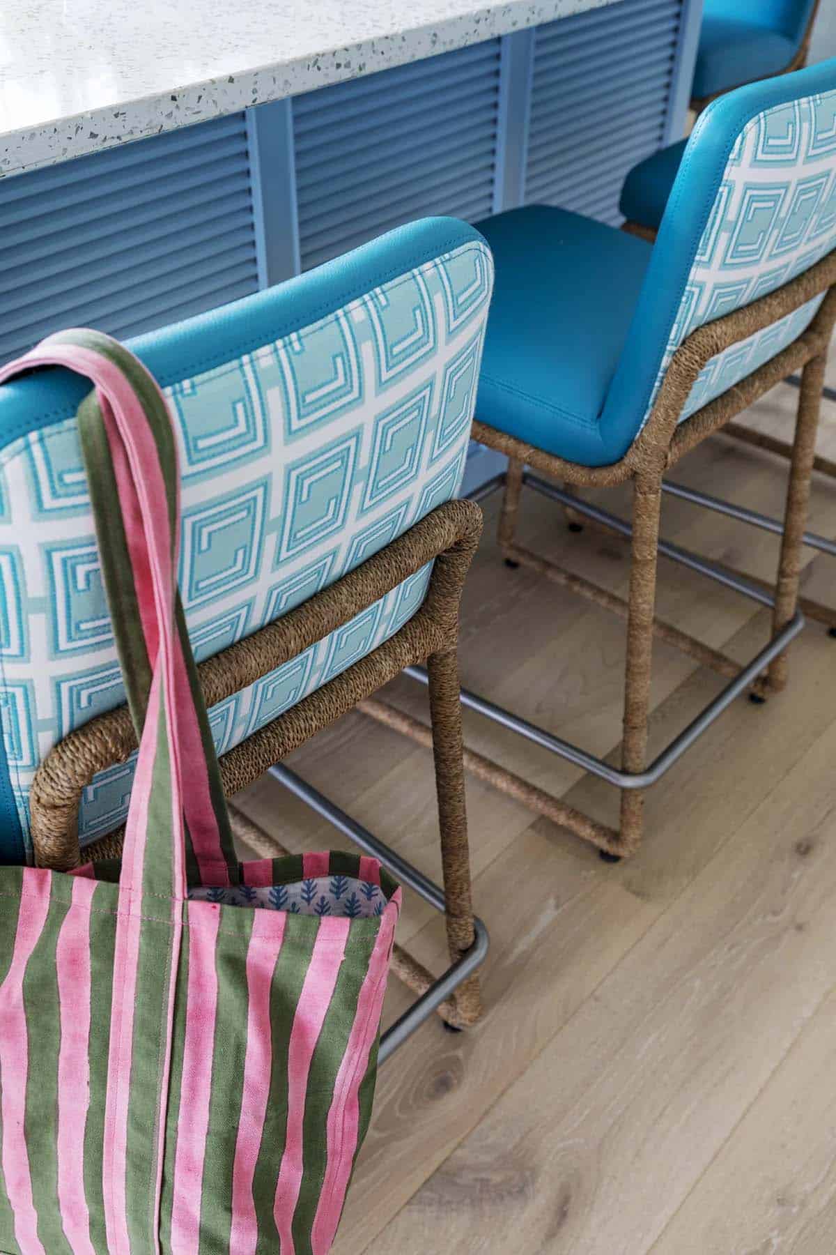 Detail of woven teal barstools and striped tote bag