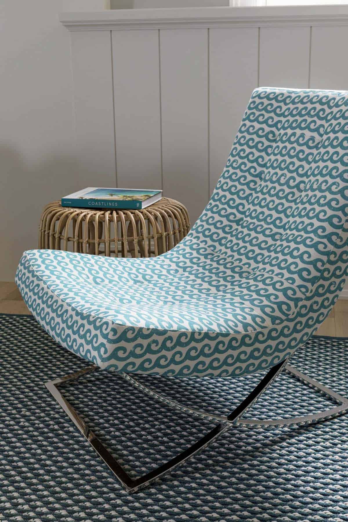 Wave-patterned swivel chair on chrome base beside rattan table