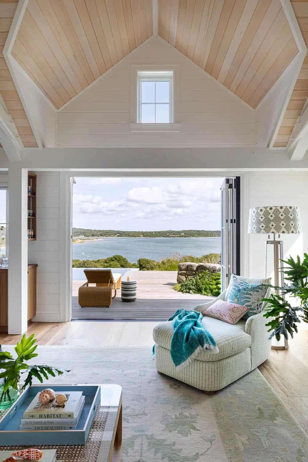 Living room chaise facing folding glass doors with panoramic water view