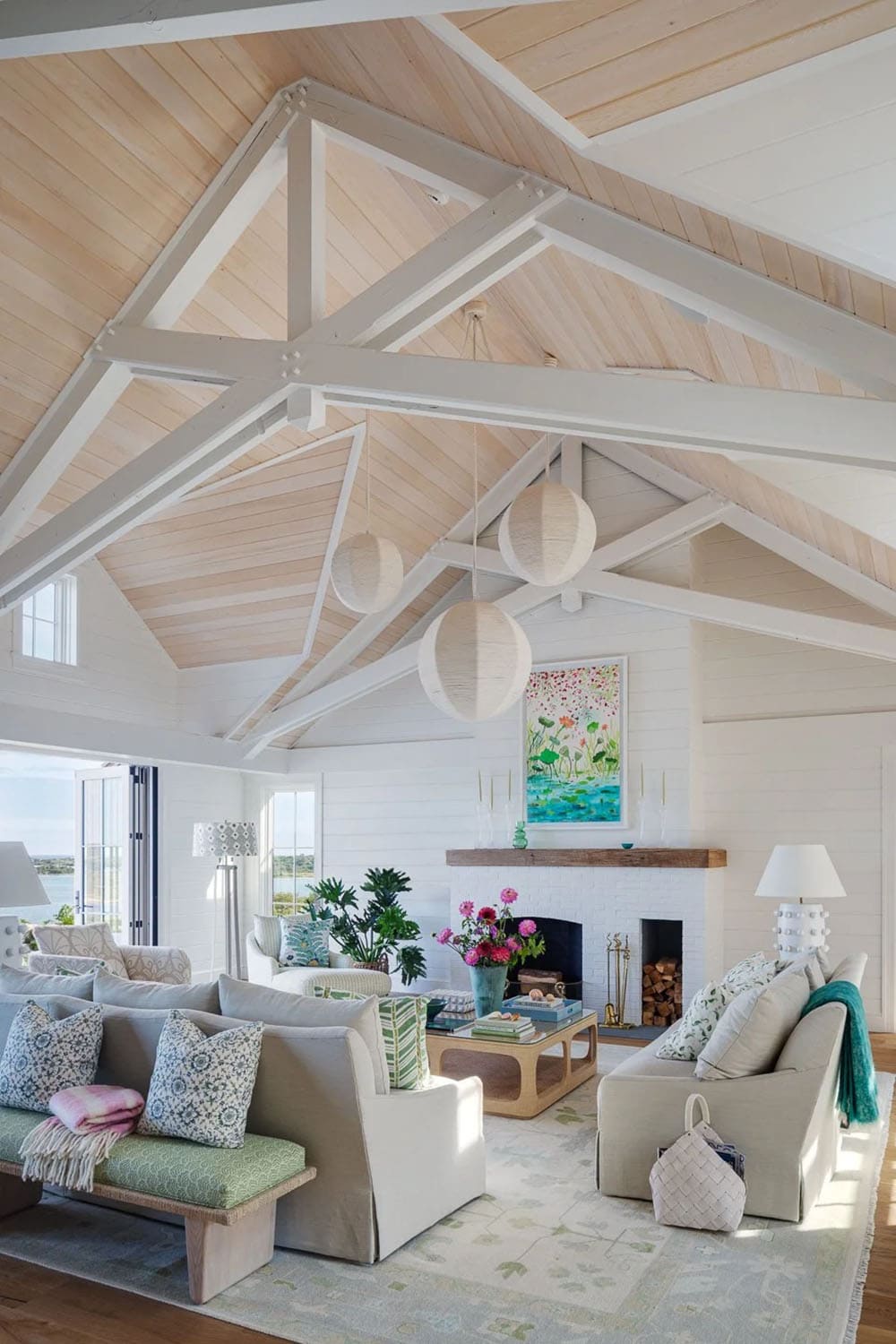 Living room with white sofas, woven pendant lights, and whitewashed brick fireplace