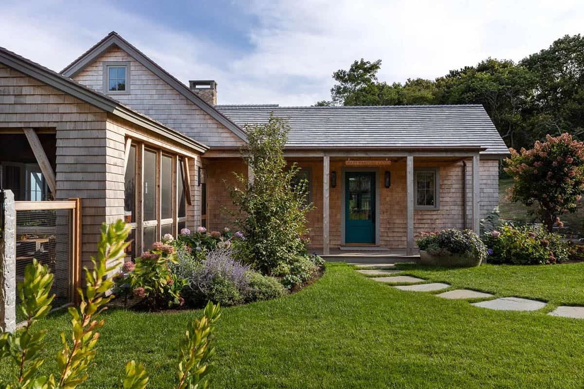 Shingle cottage exterior with teal front door and landscaped stone walkway