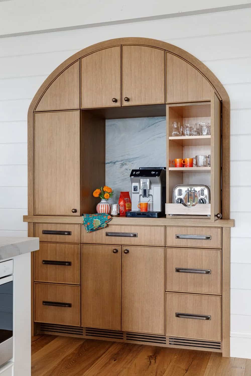 Arched wood pantry cabinet with built-in coffee station and open shelving