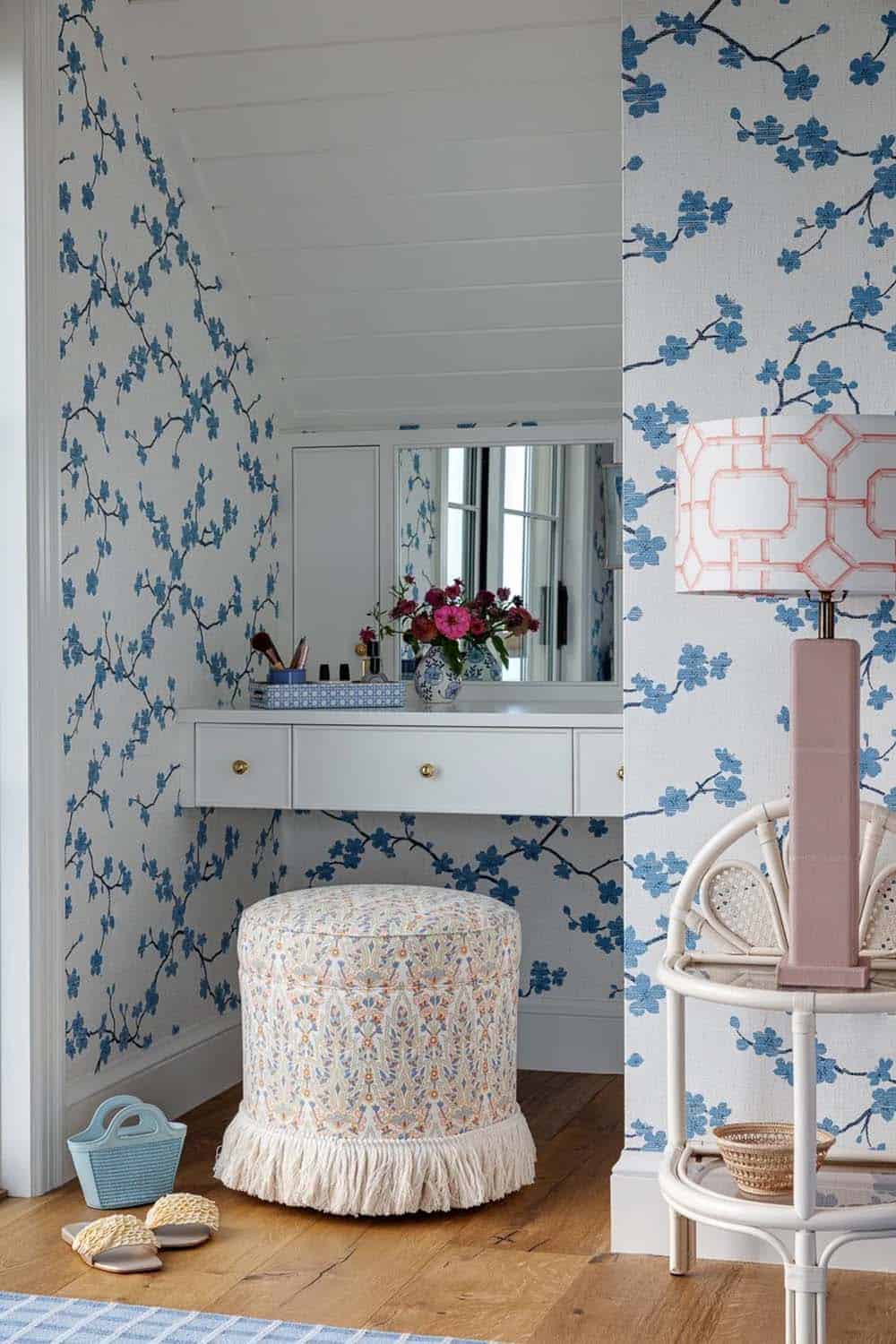 Vanity nook with cherry blossom wallpaper, mirror, and fringed patterned stool