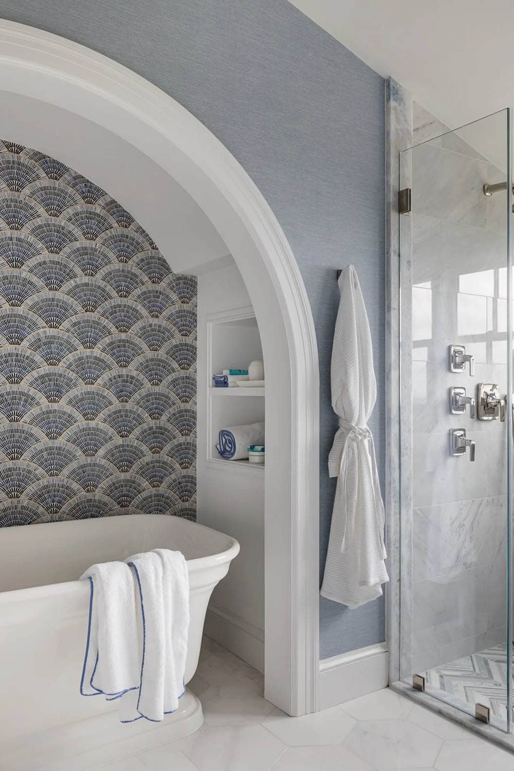 Arched alcove tub nook with scalloped fan tile and glass shower enclosure