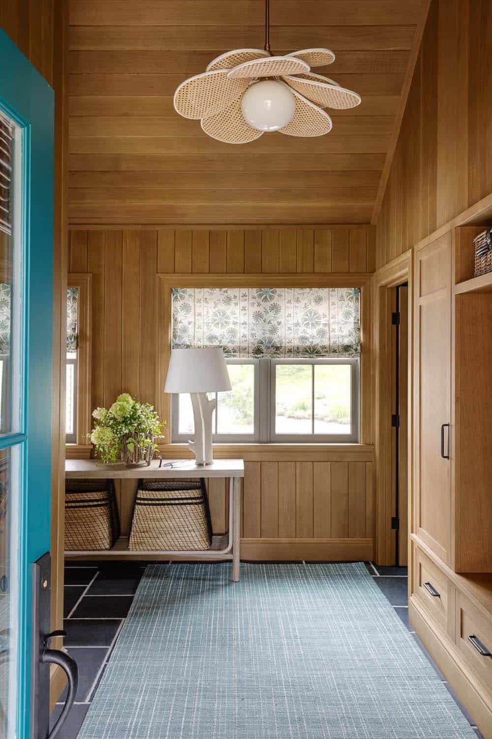 Wood-paneled mudroom hallway with woven flower pendant light and console table