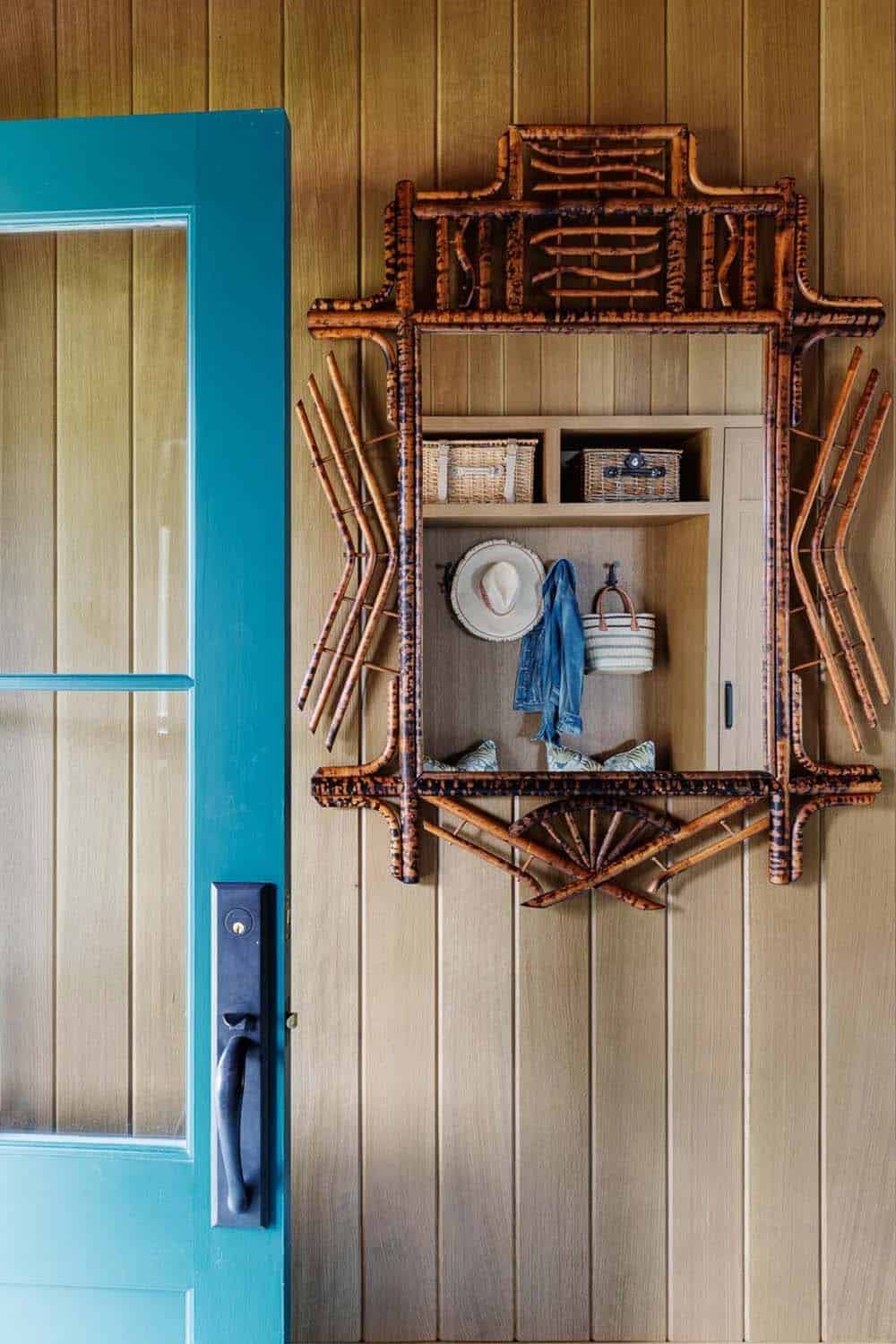 Bamboo pegboard shelf with hat and tote beside teal paneled door