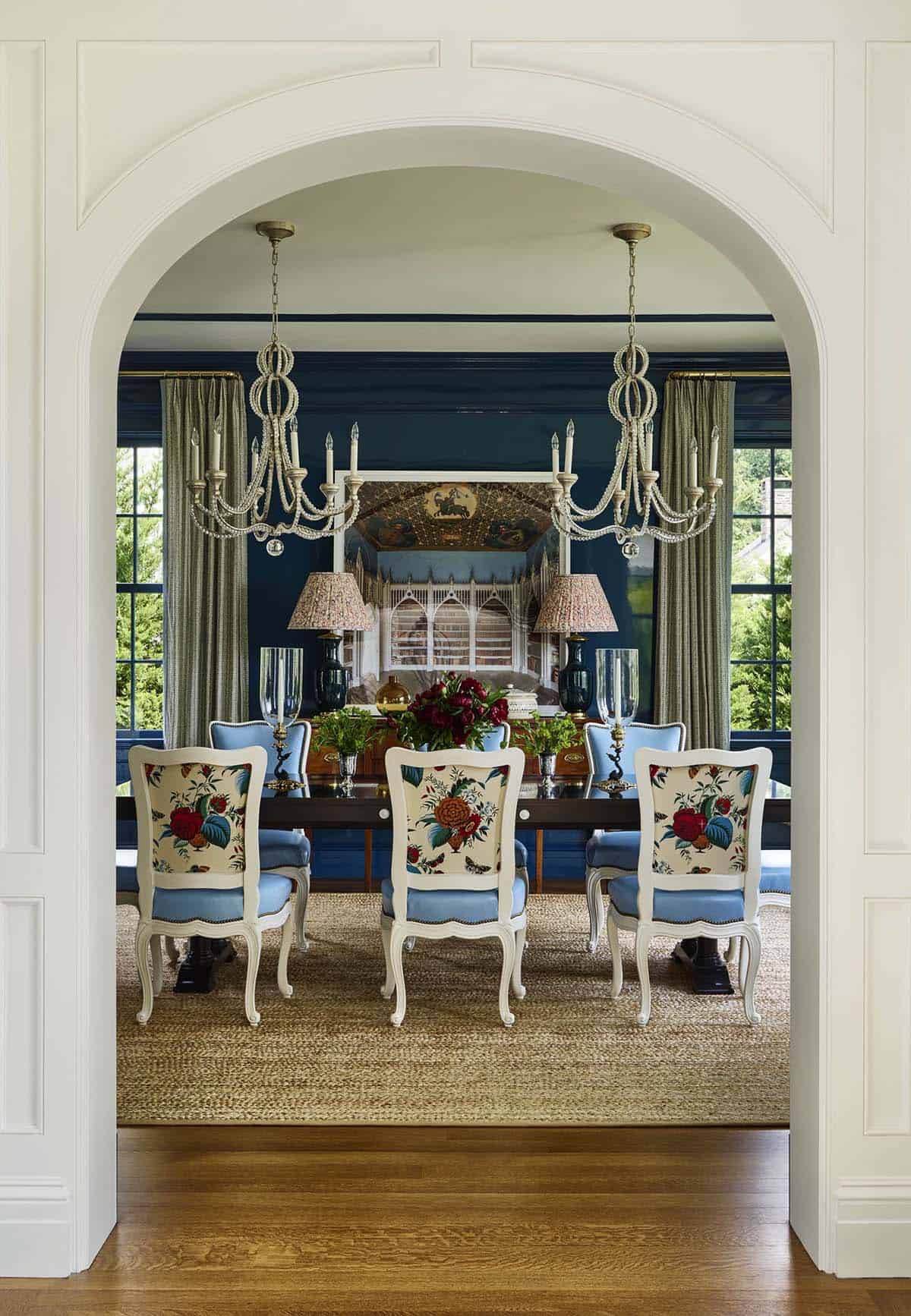Formal dining room with navy lacquered walls and floral upholstered chairs