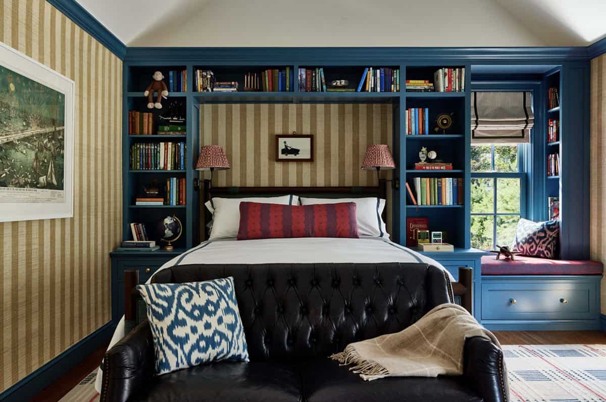 Boy's bedroom with navy built-in bookshelves and tufted leather headboard