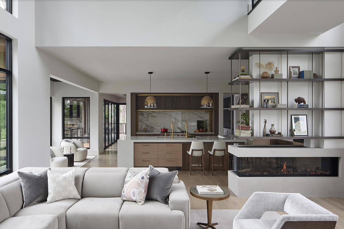 Open-concept living and kitchen area with a floating shelving unit and three-sided fireplace