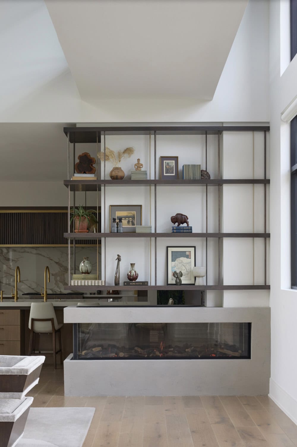 Metal shelving and fireplace unit next to the kitchen and dining area