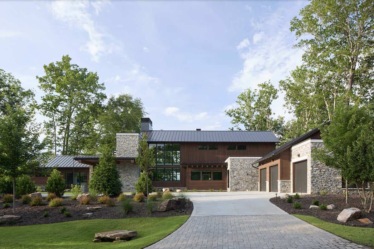Front view of the house and driveway with stone entry tower and dark metal roofline