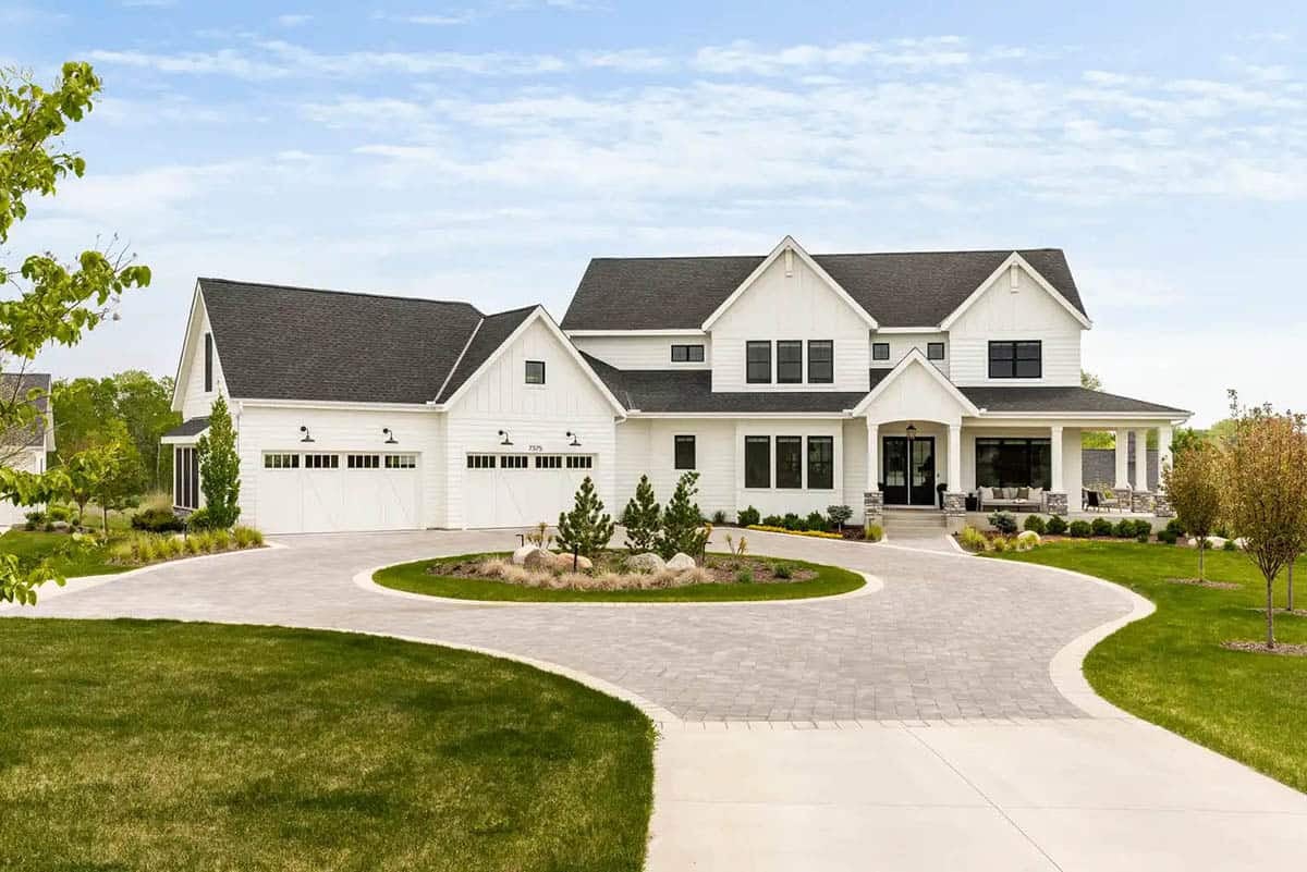 Contemporary white farmhouse exterior with circular paver driveway