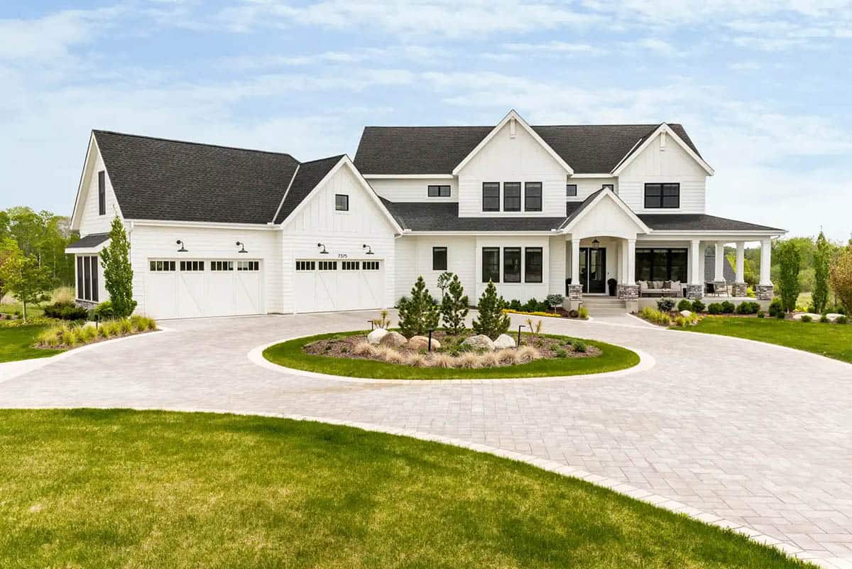 Two-story white farmhouse with dark shingle roof and three-car garage
