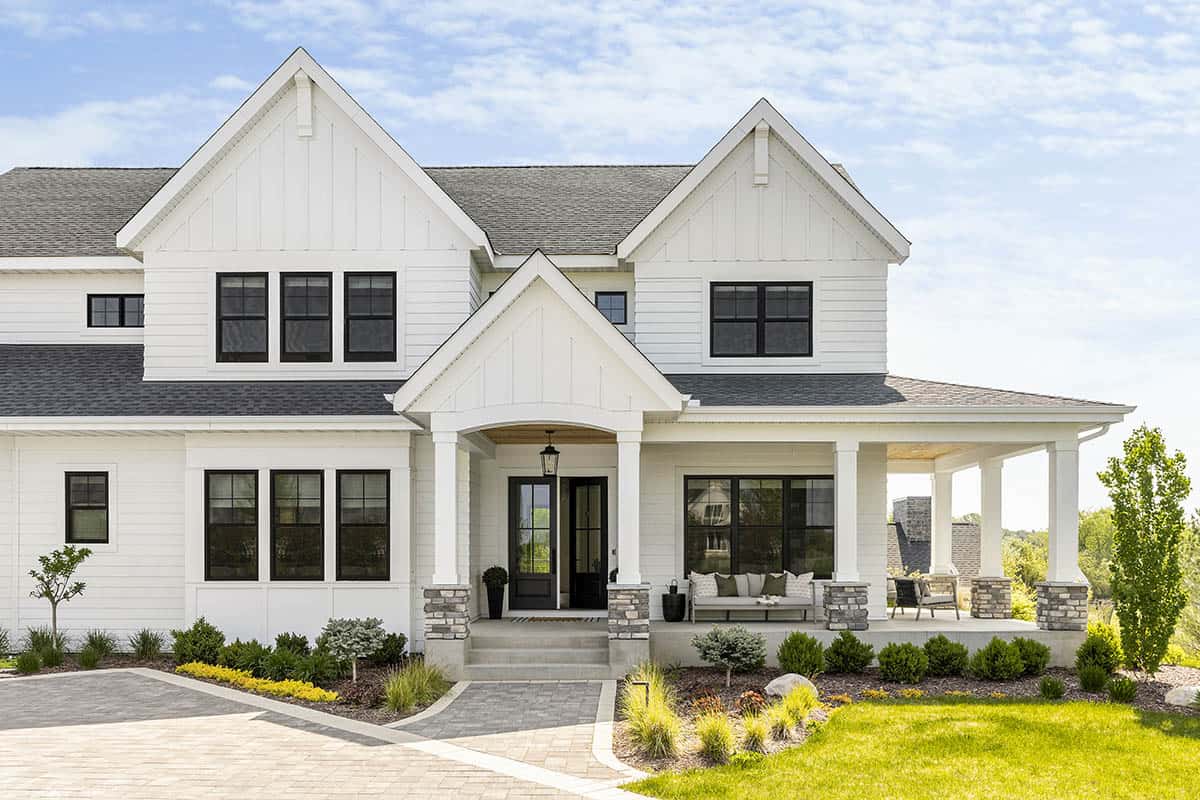 Close-up of white farmhouse gable roofline and covered front porch