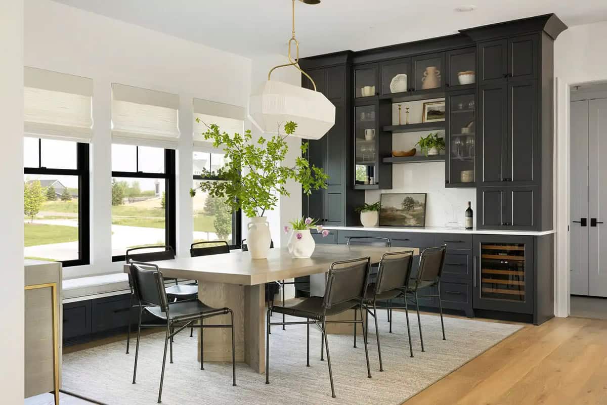 Dining room with black cabinetry, wine fridge, and pendant light