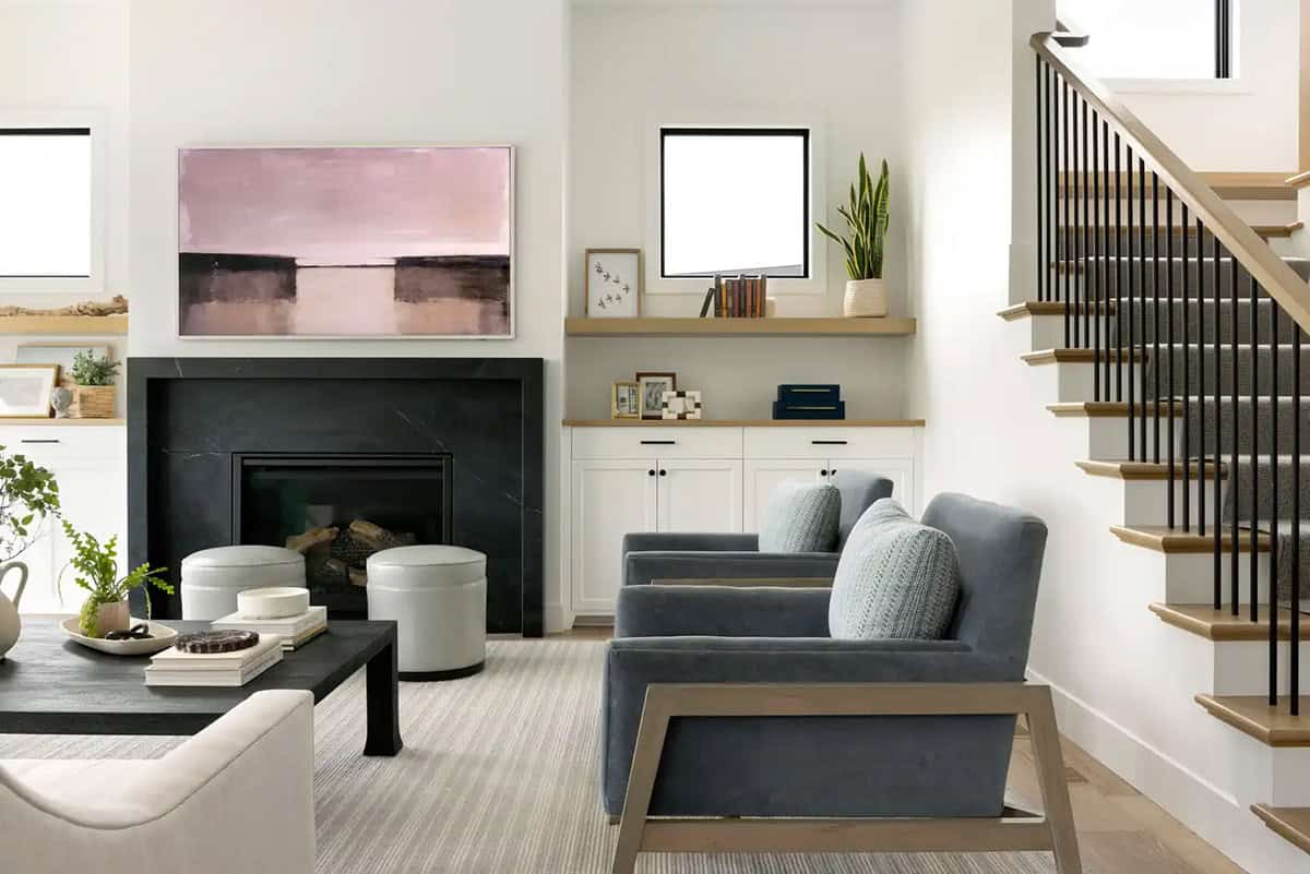 Living room with black fireplace surround and gray armchairs