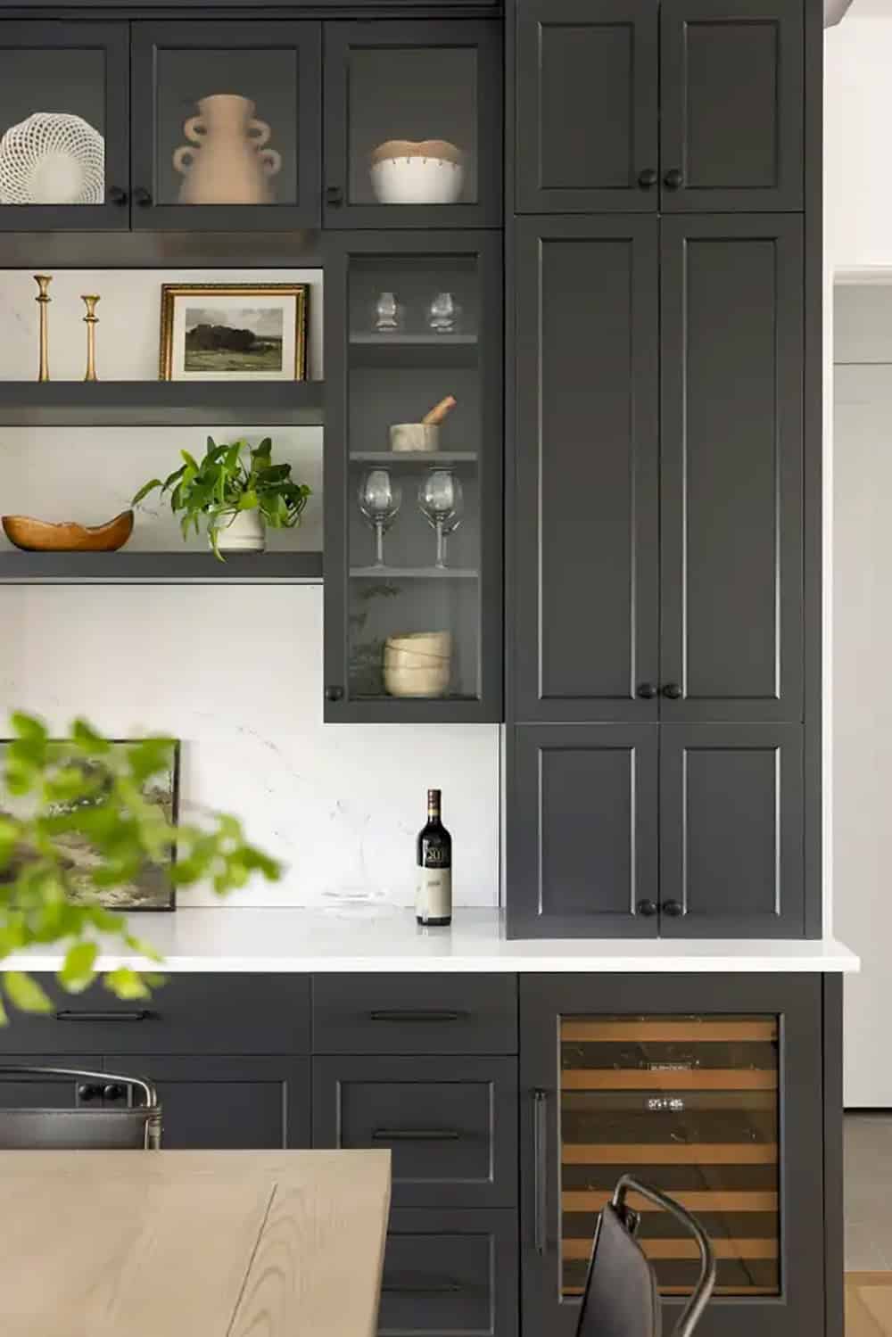 Close-up of black kitchen cabinetry with open shelving and wine fridge