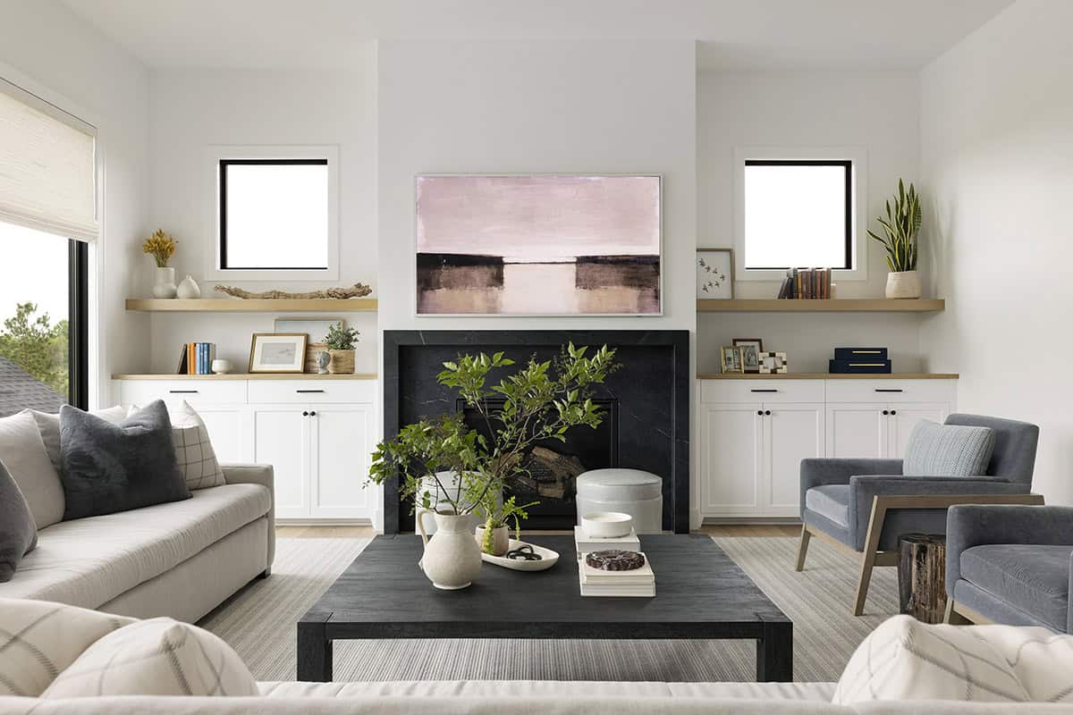 Living room with wall-mounted TV above black fireplace surround