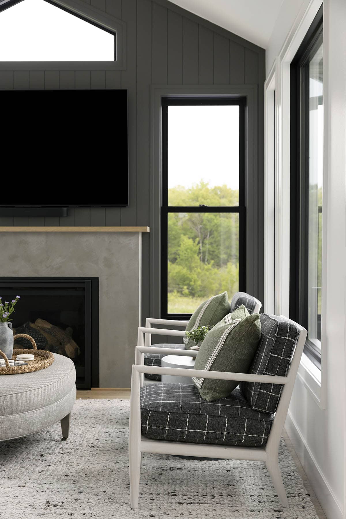 Sunroom seating area with plaid armchairs and wall-mounted TV