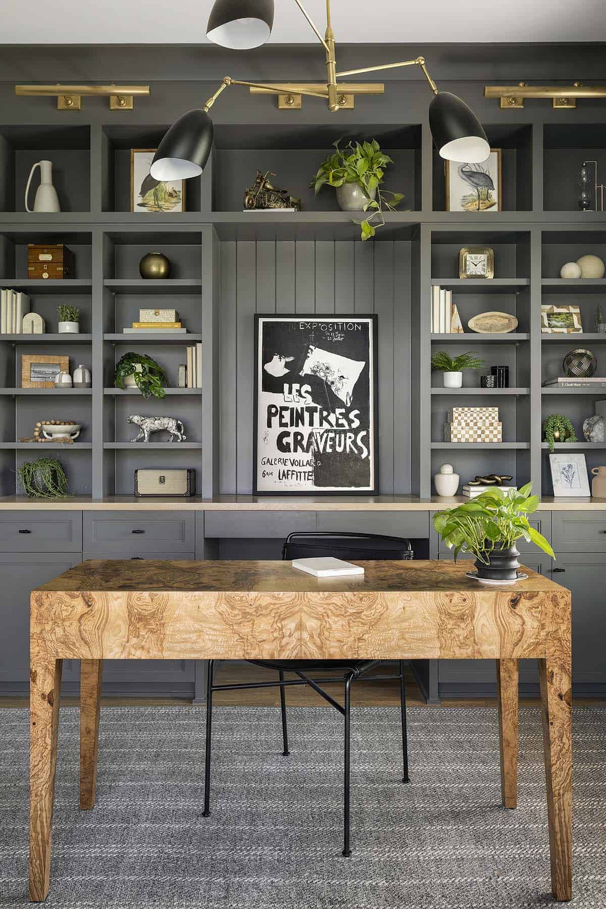 Close-up of gray built-in bookshelves with brass task lighting