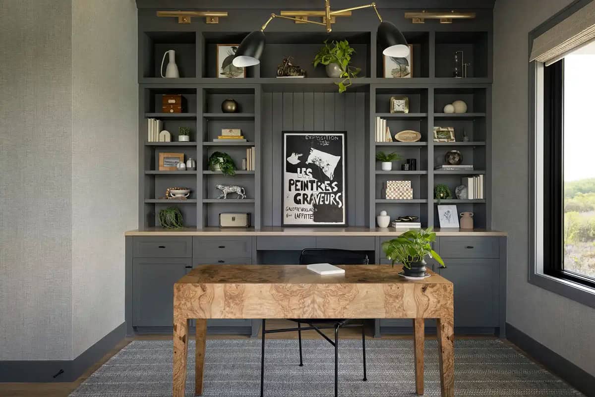 Home office desk with wood grain top and gallery of shelf decor