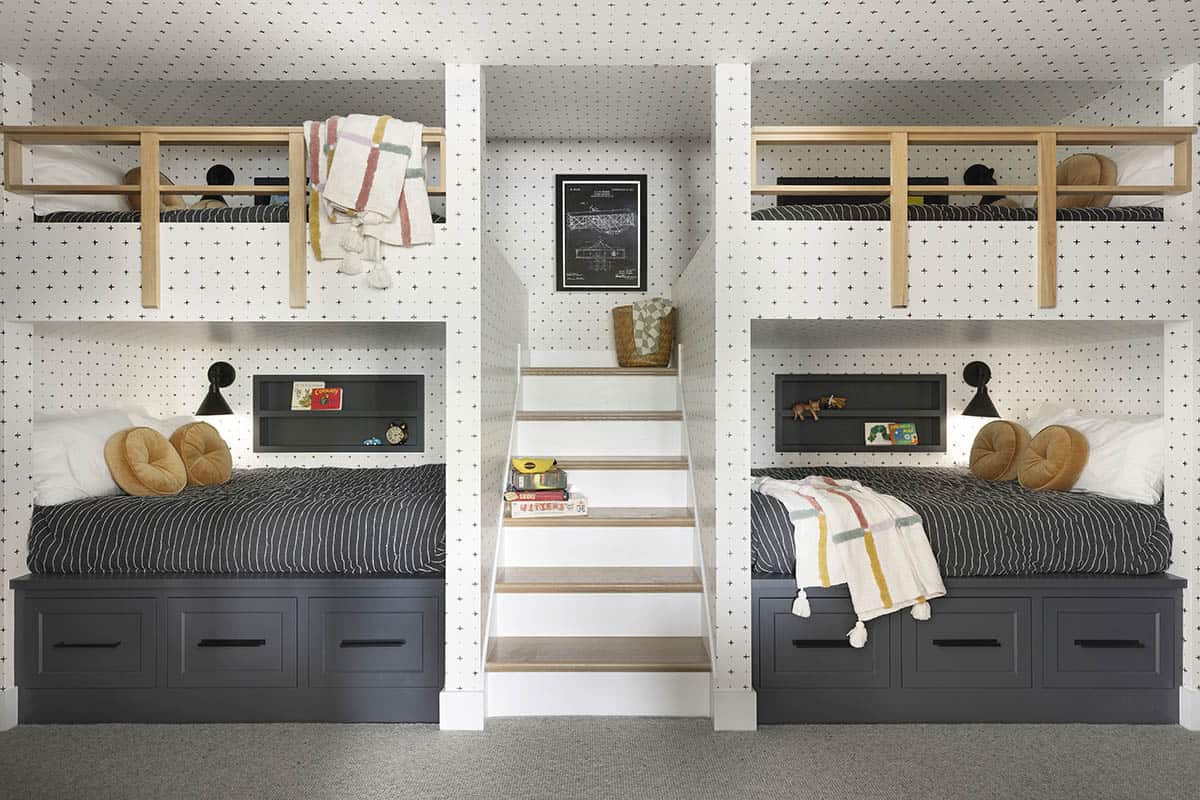 Built-in bunk beds with patterned wallpaper and center staircase