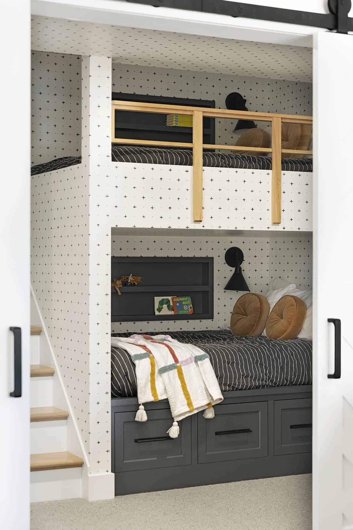 Close-up of built-in bunk bed nook with striped bedding and shelf